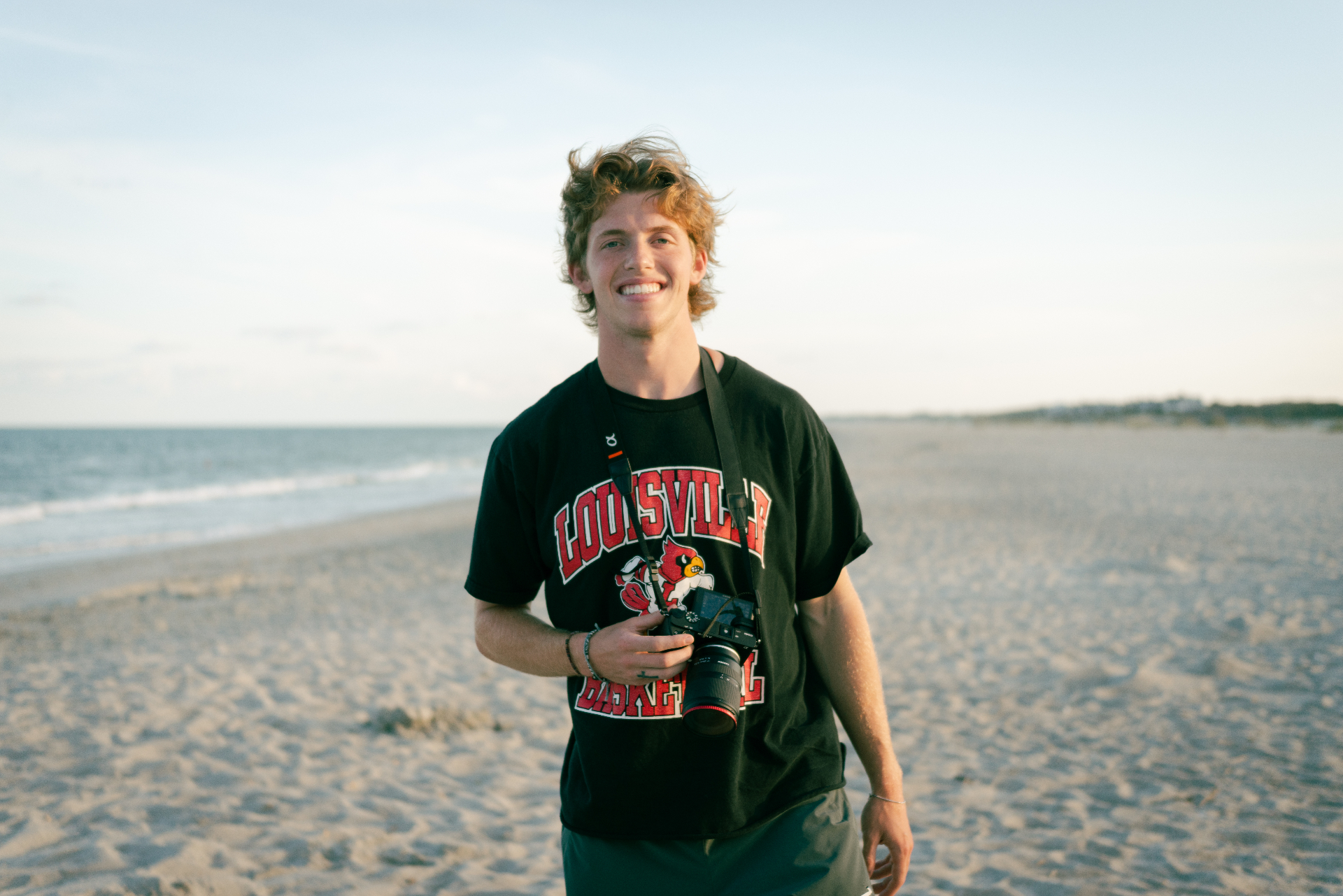 Portrait of von Arx on the beach with a camera at golden hour